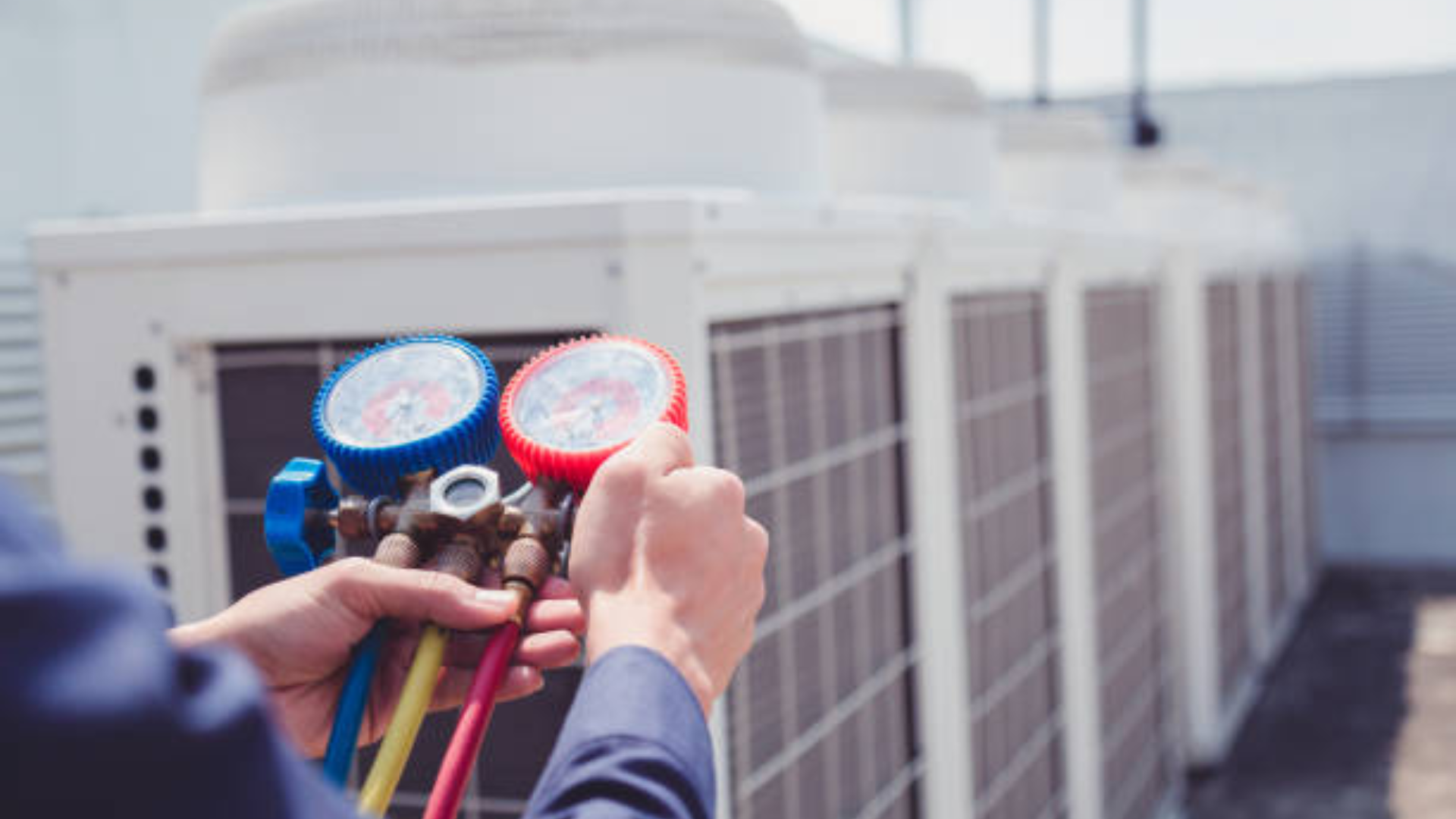 HVAC technician checking commercial unit gauges